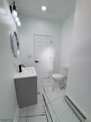a spacious bathroom with a toilet a sink and mirror