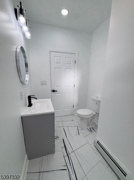 48 North York Street, Unit 1F Paterson, NJ 07524 - Photo 9 of 18 a spacious bathroom with a toilet a sink and mirror