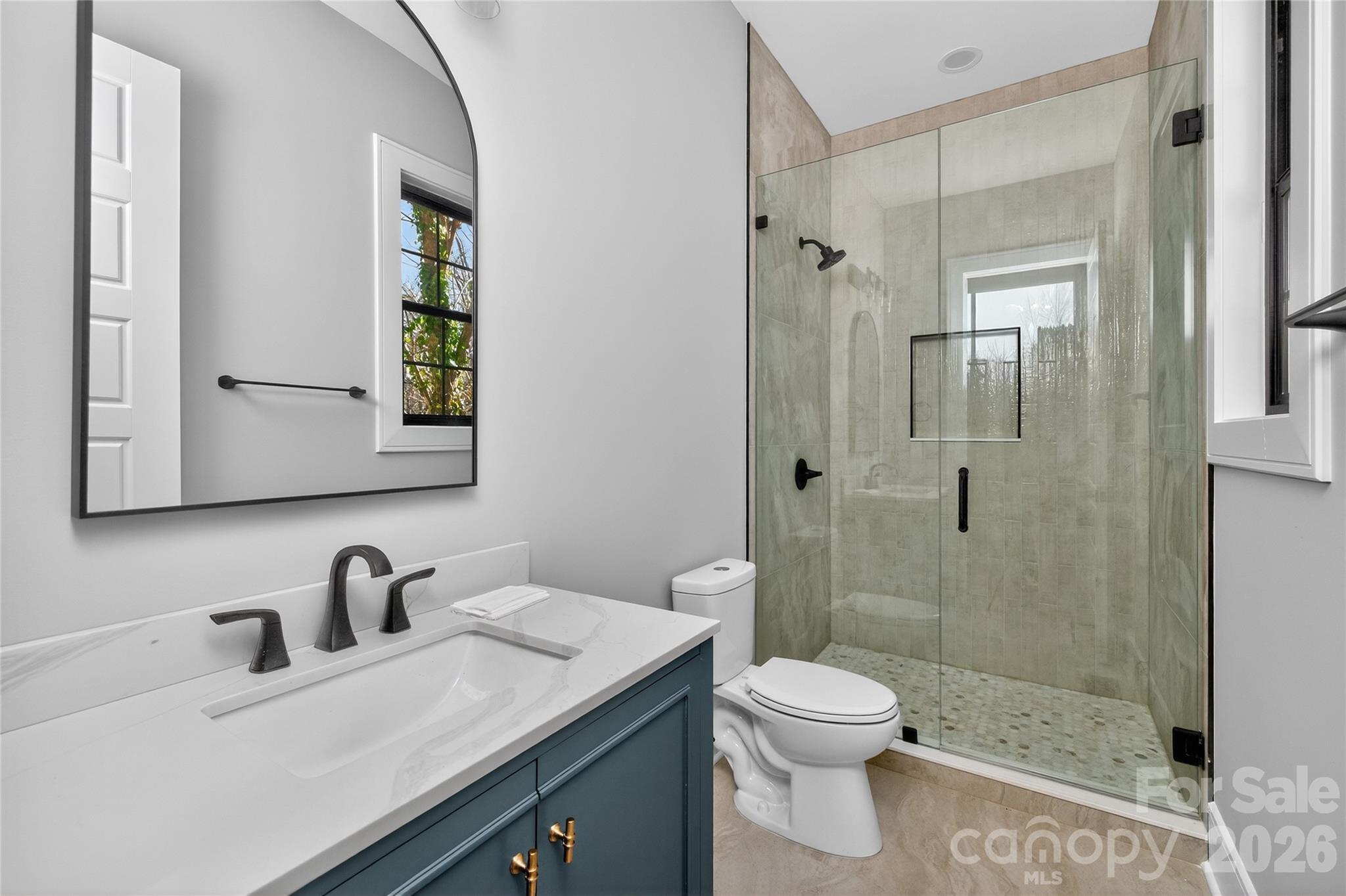 6811 Burlwood Road Charlotte, NC 28211 - Photo 20 of 43 a bathroom with a sink toilet a mirror and shower