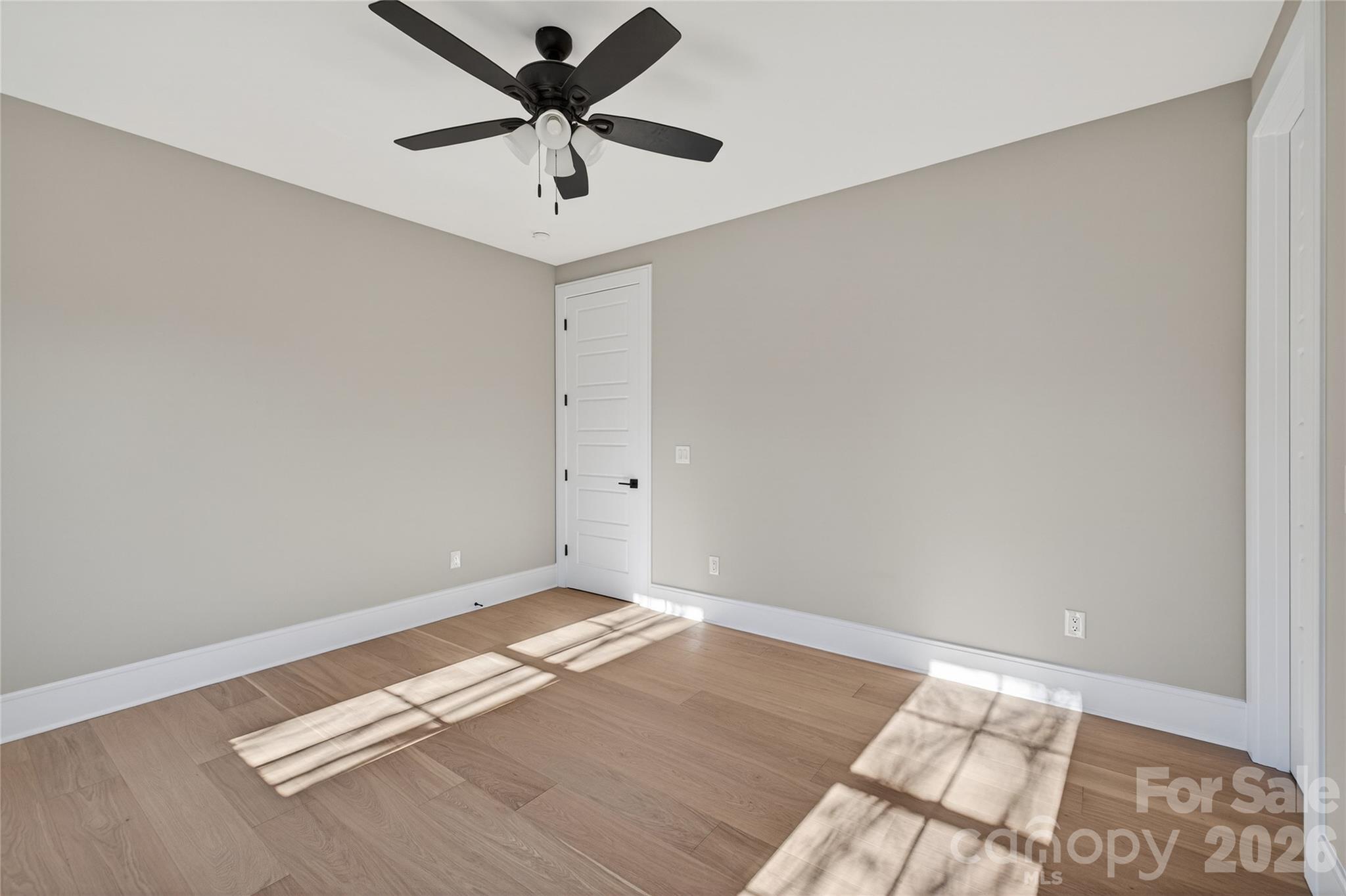 6811 Burlwood Road Charlotte, NC 28211 - Photo 30 of 43 an empty room with a ceiling fan and wooden floor