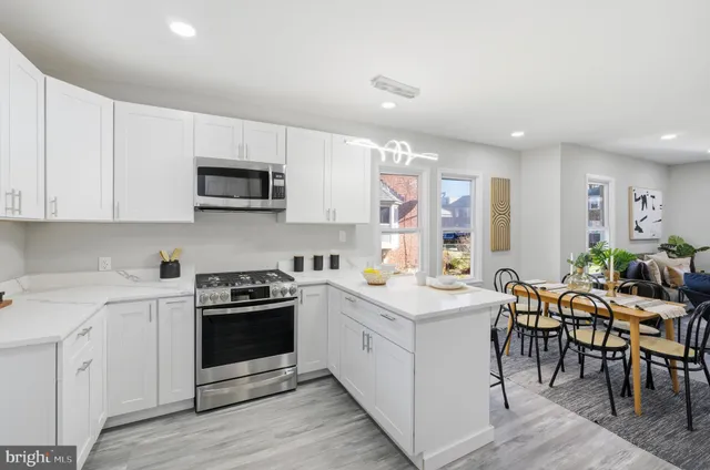 a kitchen with stainless steel appliances a refrigerator a stove a sink and a cabinets