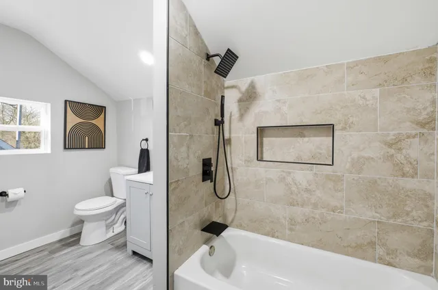 a white toilet sitting next to a bath tub