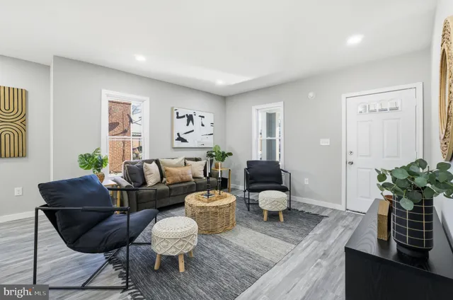 a living room with furniture and a dining table with wooden floor
