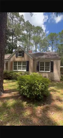 a view of a big house with a big yard and large trees