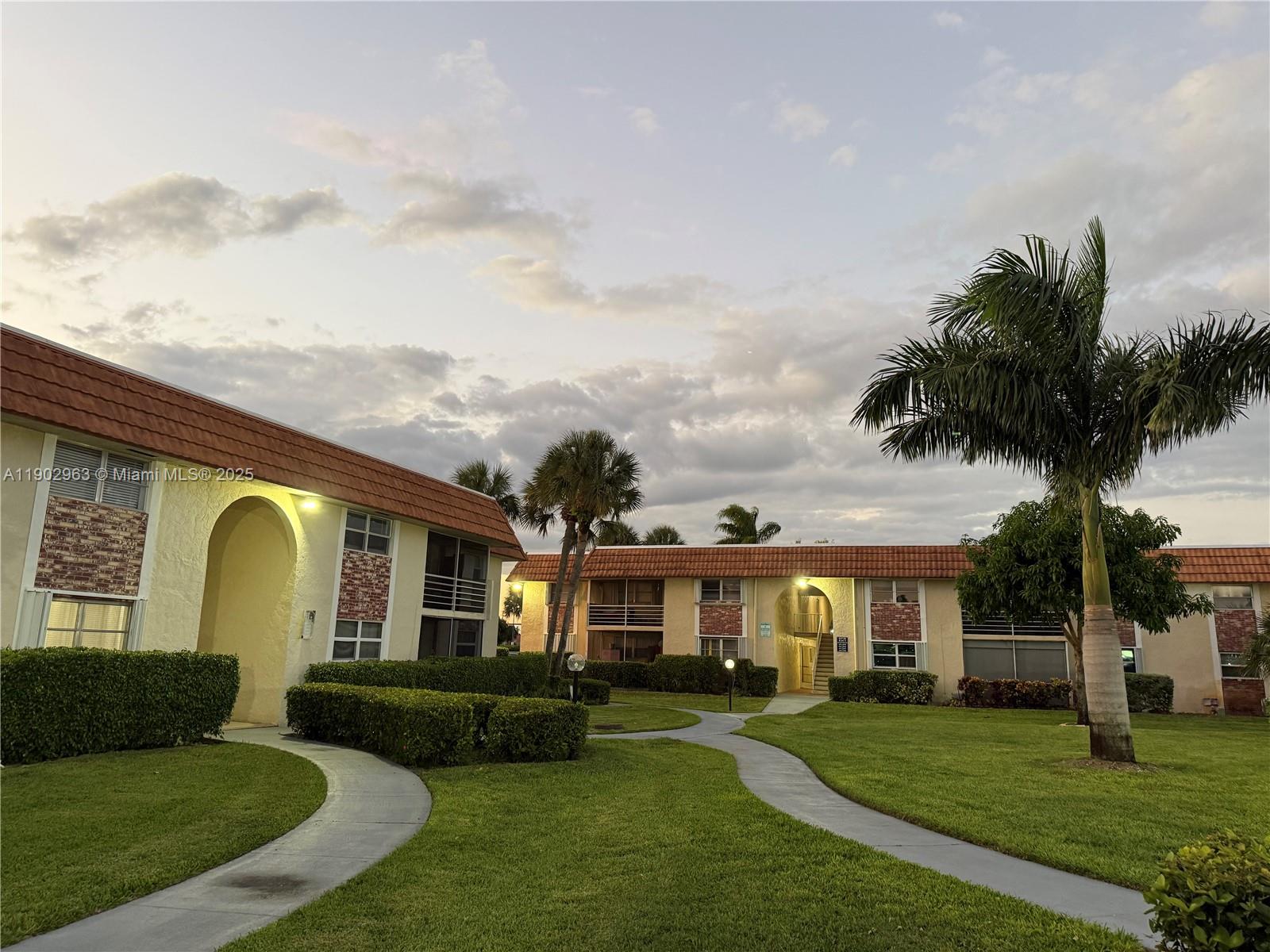 22805 Southwest 66th Avenue, Unit 208 Boca Raton, FL 33428 - Photo 13 of 22 a front view of a house with garden