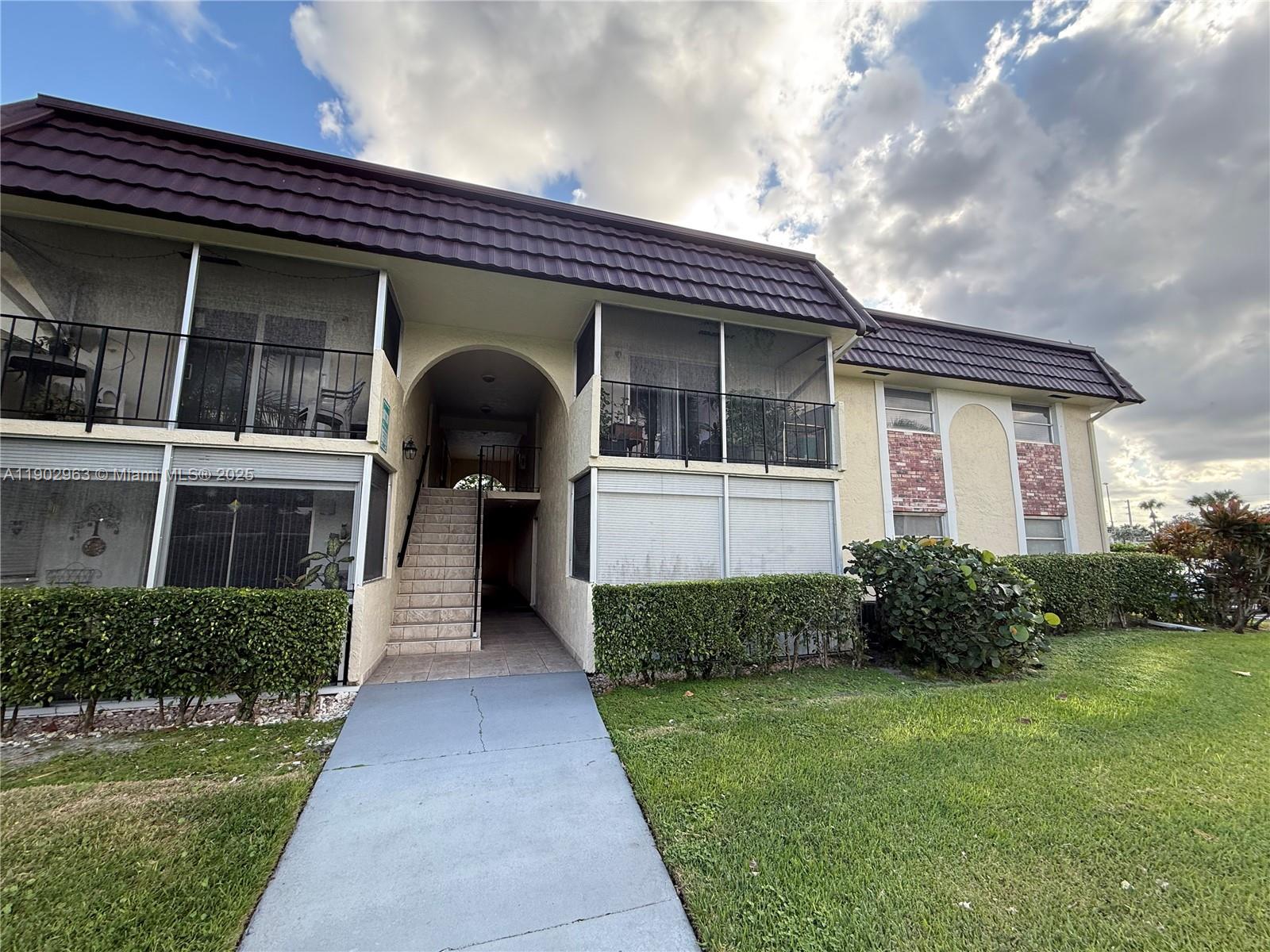 22805 Southwest 66th Avenue, Unit 208 Boca Raton, FL 33428 - Photo 16 of 22 a front view of a house with garden