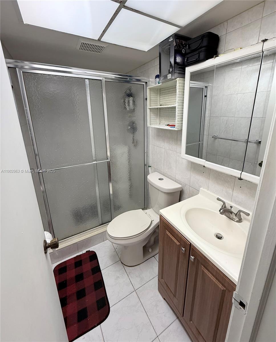 22805 Southwest 66th Avenue, Unit 208 Boca Raton, FL 33428 - Photo 7 of 22 a bathroom with a sink a toilet and shower