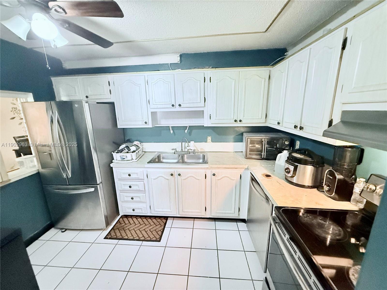 22805 Southwest 66th Avenue, Unit 208 Boca Raton, FL 33428 - Photo 8 of 22 a kitchen with a refrigerator a stove a sink and cabinets