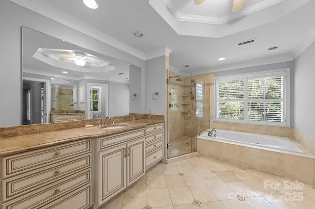 a spacious bathroom with a granite countertop tub shower double vanity and mirror