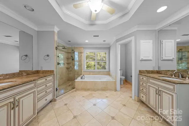 a spacious bathroom with a granite countertop sink a mirror a vanity and a bathtub
