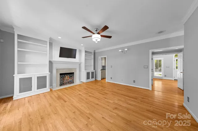 a view of empty room with fireplace and wooden floor