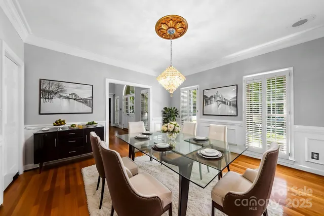 a view of a dining room with furniture a chandelier and wooden floor