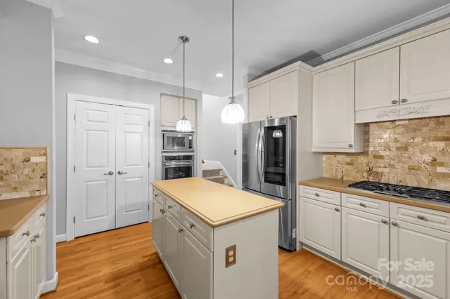 a kitchen with white cabinets and refrigerator
