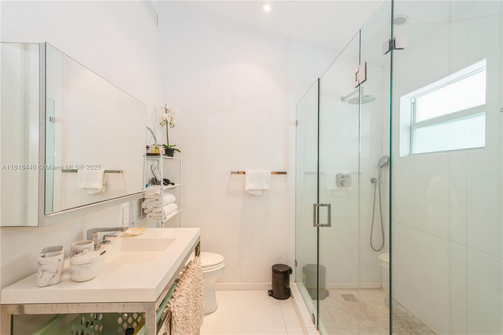 798 Crandon Boulevard, Unit 55B Key Biscayne, FL 33149 - Photo 3 of 8 a bathroom with a sink mirror and shower