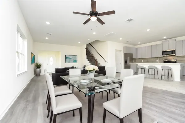 a view of a dining room with furniture a rug and wooden floor