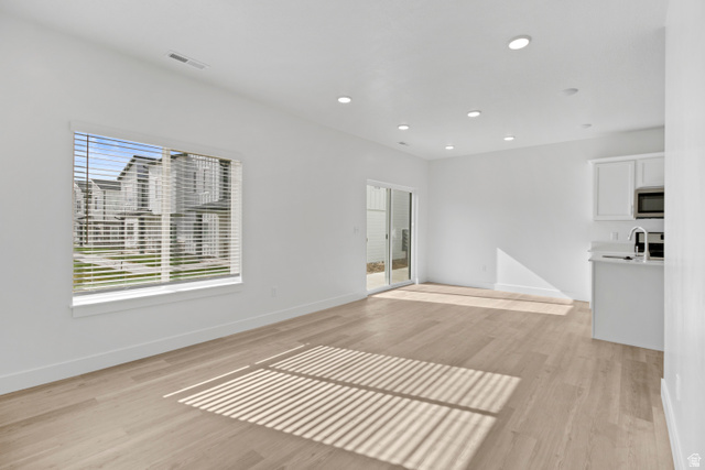 1271 West 500 South Logan, UT 84321 - Photo 3 of 26 Open concept living area featuring light wood-finish flooring, recessed lighting, a large window with blinds, and a sliding glass door to the exterior
