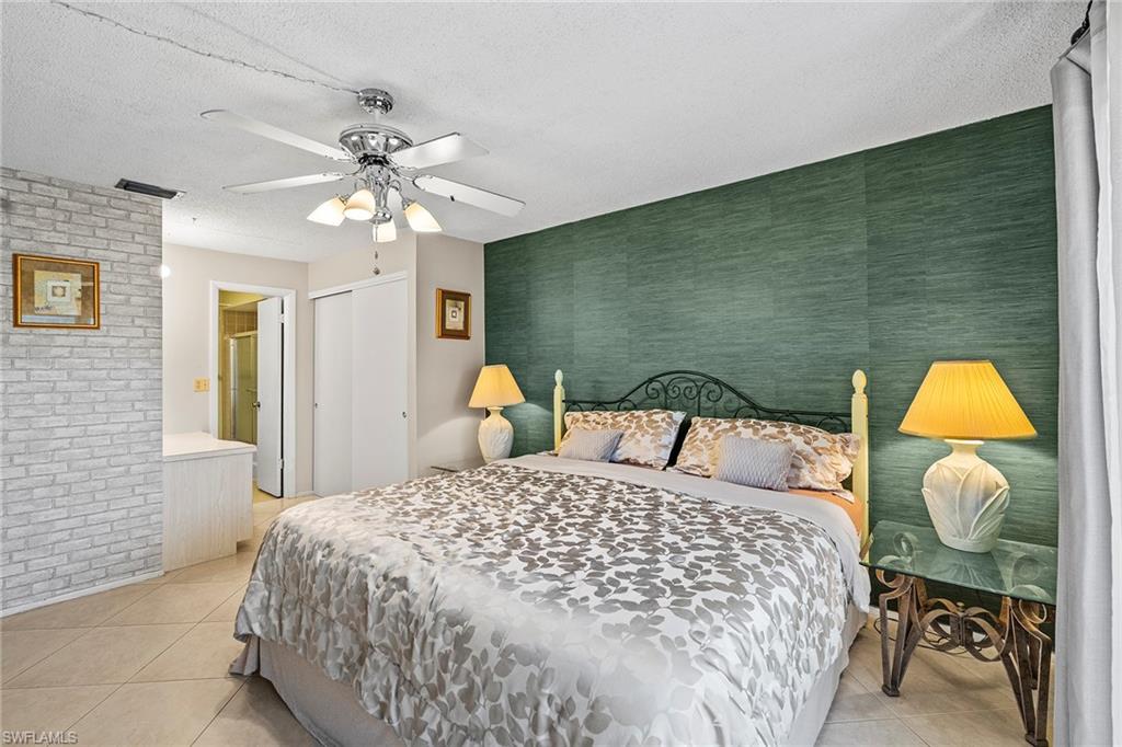 131 Teryl Road, Unit C3 Naples, FL 34112 - Photo 20 of 26 a bedroom with a bed and a chandelier