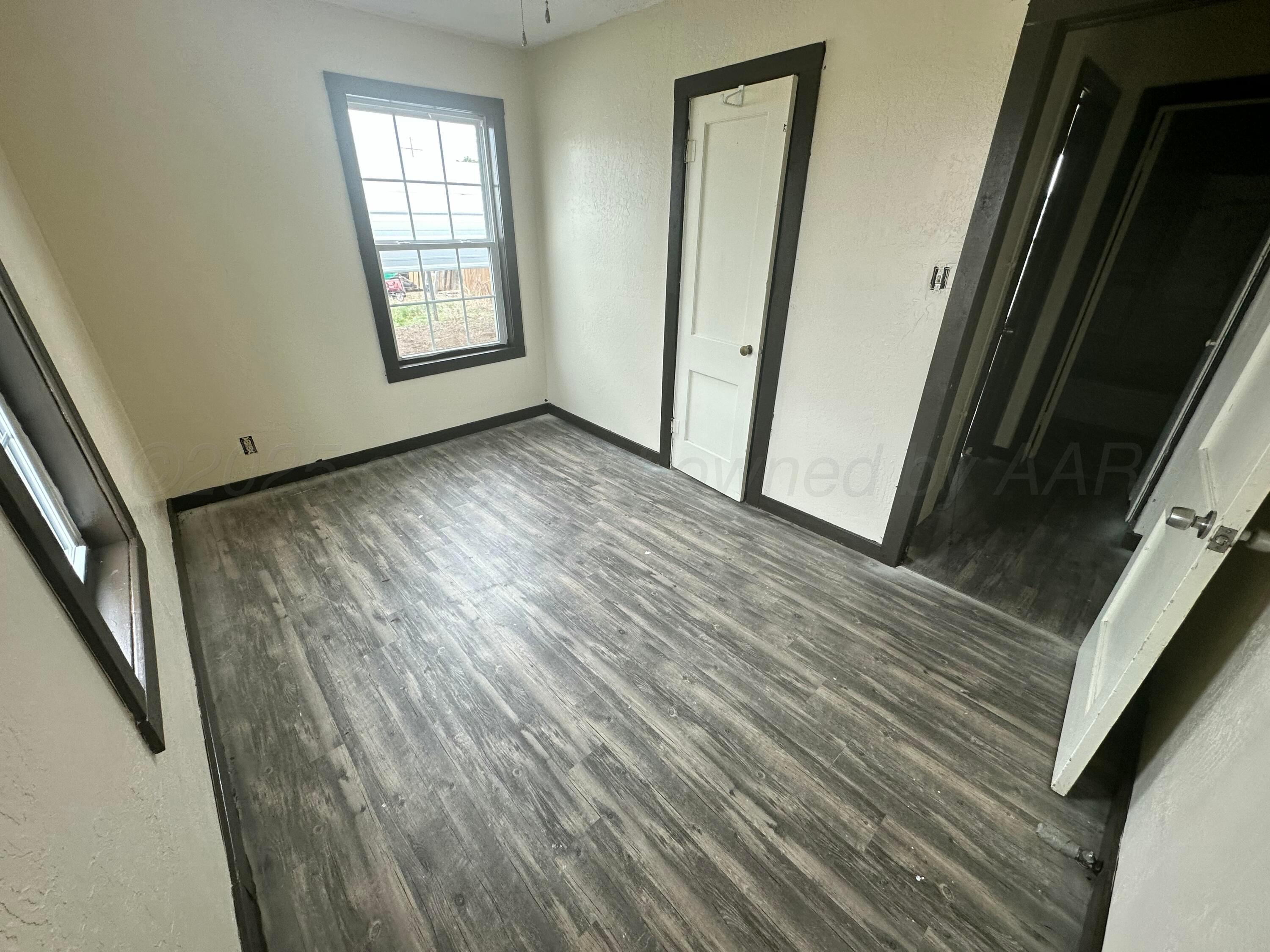709 Flora Avenue Panhandle, TX 79068 - Photo 14 of 19 an empty room with wooden floor and windows