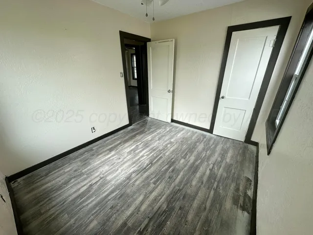 a view of empty room with wooden floor