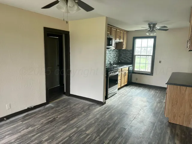 a kitchen with a refrigerator and a stove top oven