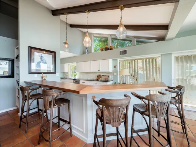 a dining hall with stainless steel appliances granite countertop a table and chairs