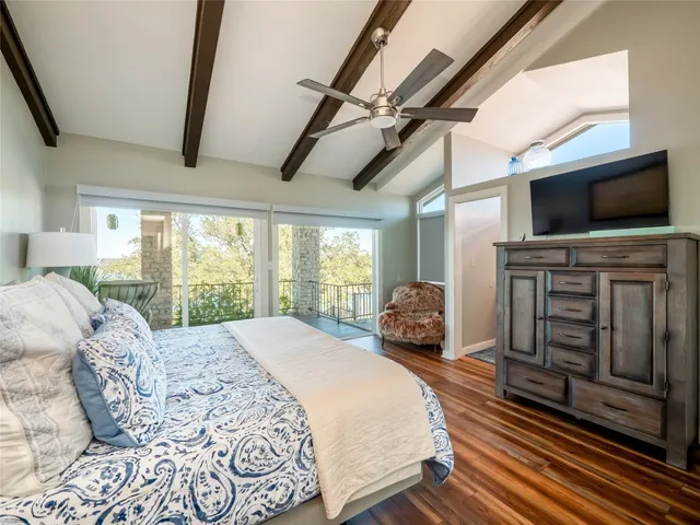 a spacious bedroom with a bed and a flat screen tv