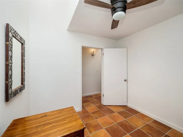 a bedroom with a bed and a ceiling fan