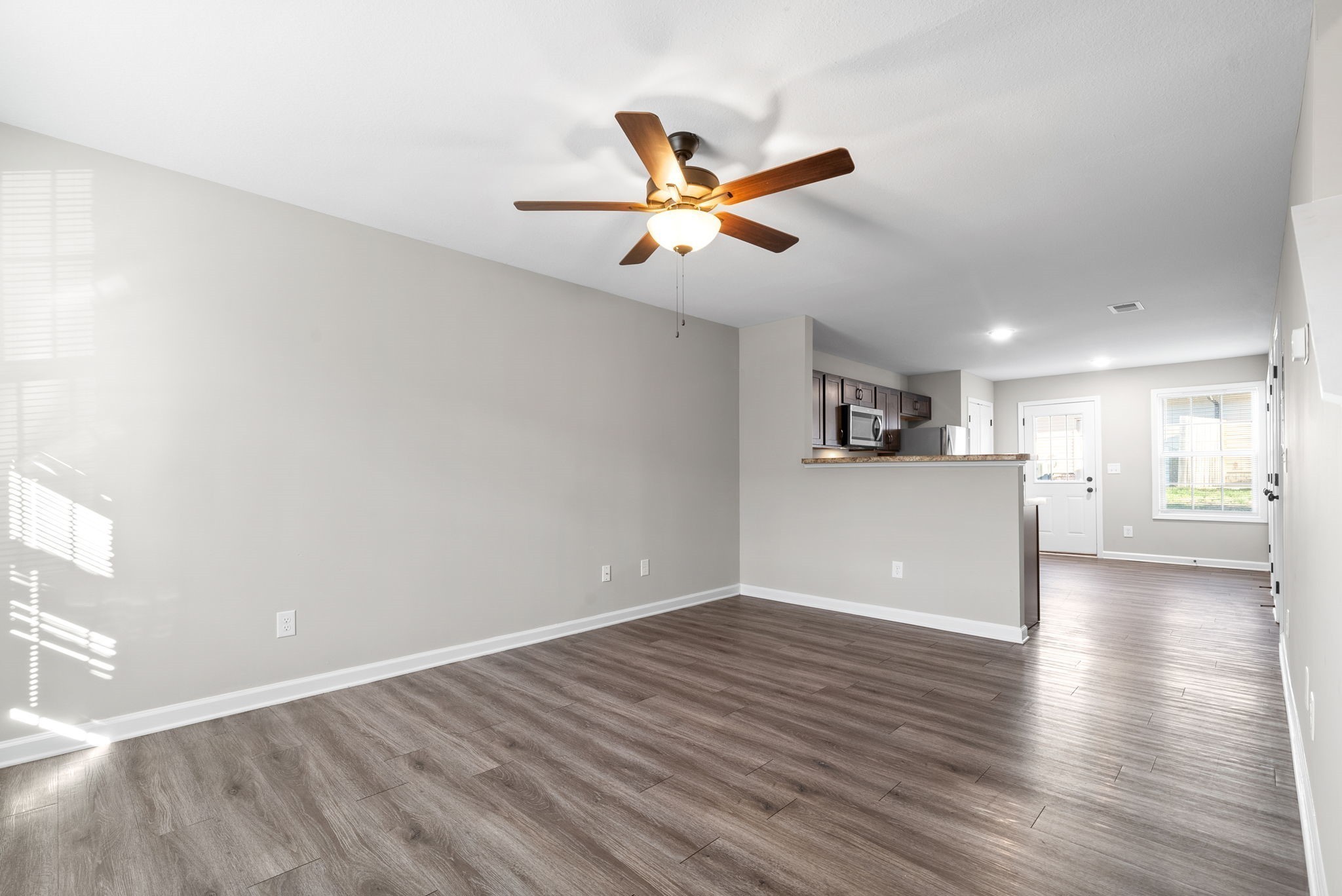 264 Smithson Lane, Unit B Clarksville, TN 37040 - Photo 5 of 25 a view of a kitchen with wooden floor and a ceiling fan