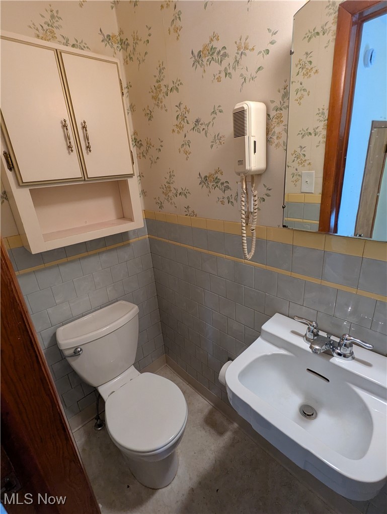 815 East Schaaf Road Independence, OH 44131 - Photo 23 of 36 Bathroom featuring toilet, sink, and tile walls