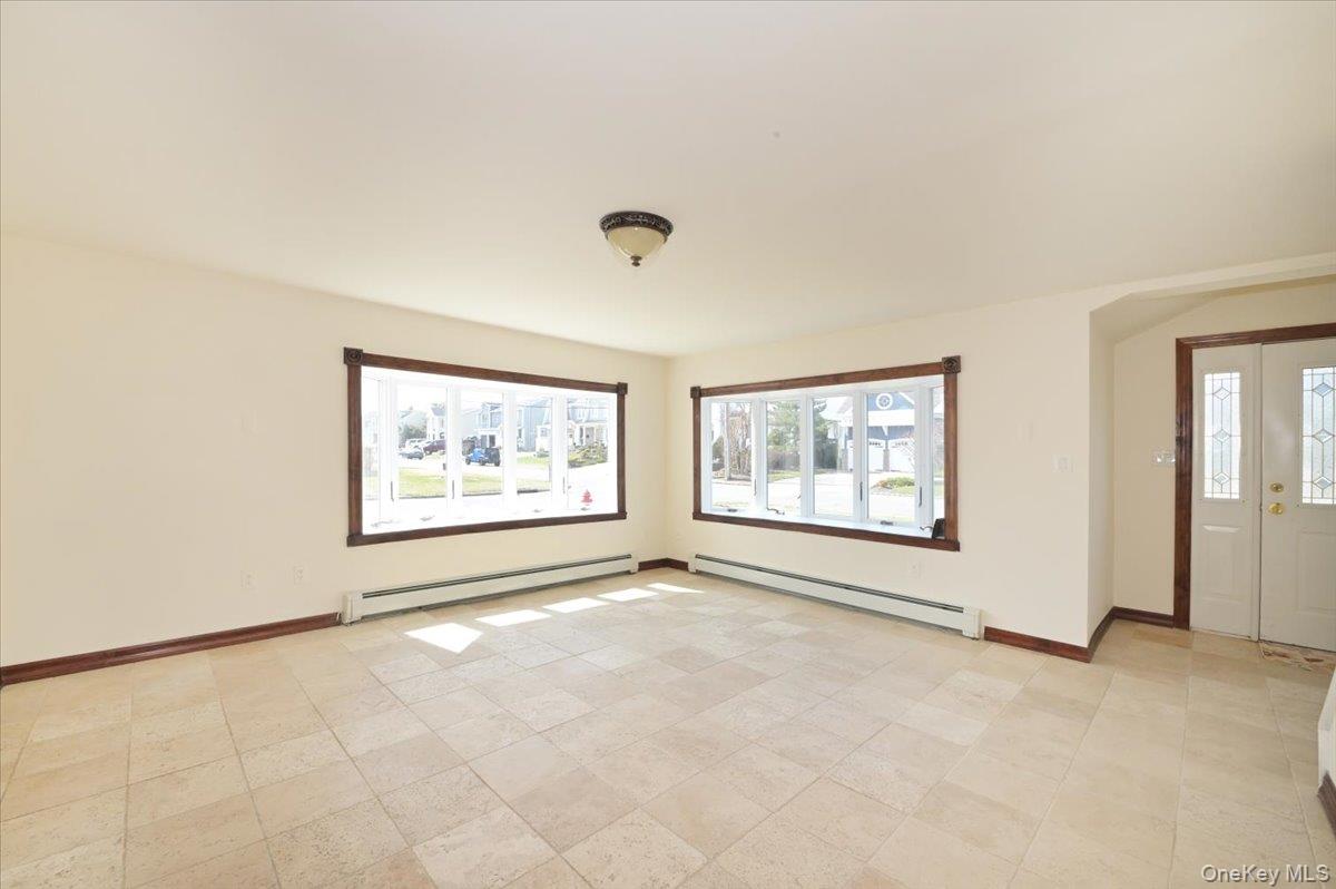 9 Cabot Road West Massapequa, NY 11758 - Photo 11 of 41 an empty room with windows and lots of painting on the wall