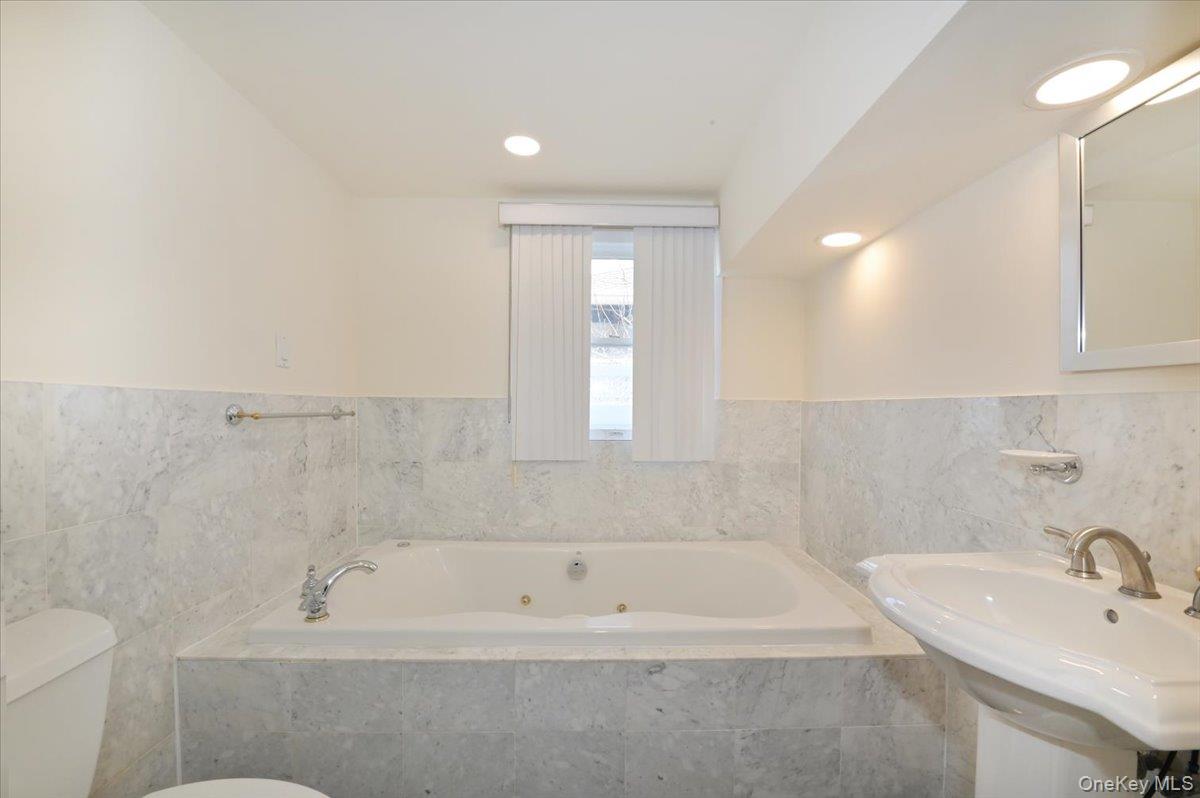 9 Cabot Road West Massapequa, NY 11758 - Photo 21 of 41 a bathroom with a bathtub and a sink