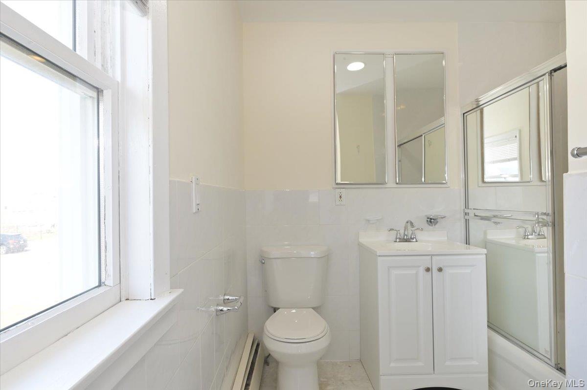 9 Cabot Road West Massapequa, NY 11758 - Photo 25 of 41 a bathroom with a toilet sink and mirror with window