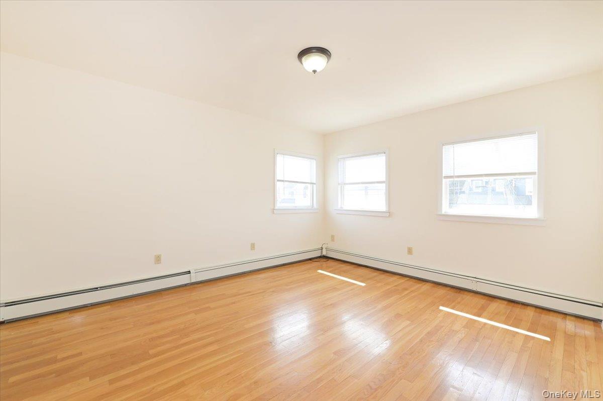 9 Cabot Road West Massapequa, NY 11758 - Photo 26 of 41 an empty room with wooden floor and windows