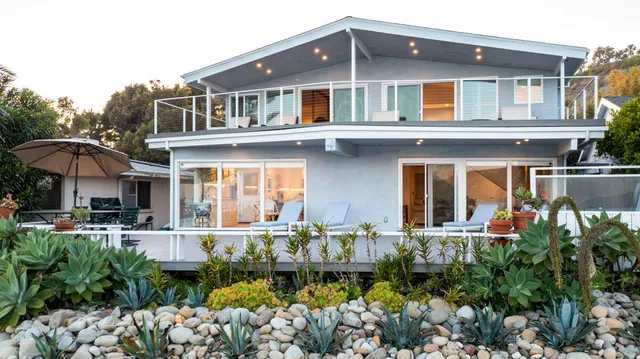 a front view of a house with a yard and outdoor seating