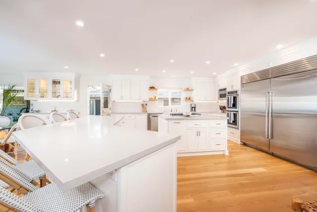 a large white kitchen with a large window