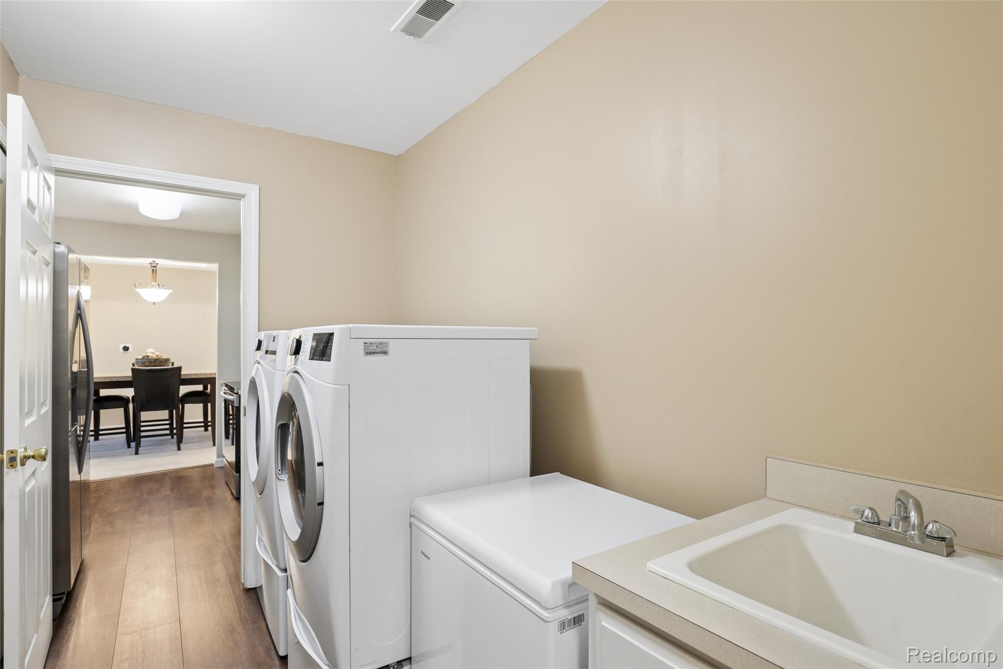 11862 Farmington Road Livonia, MI 48150 - Photo 11 of 29 Dedicated laundry area featuring wood-finish flooring, a utility sink with a laminate countertop, and neutral wall paint