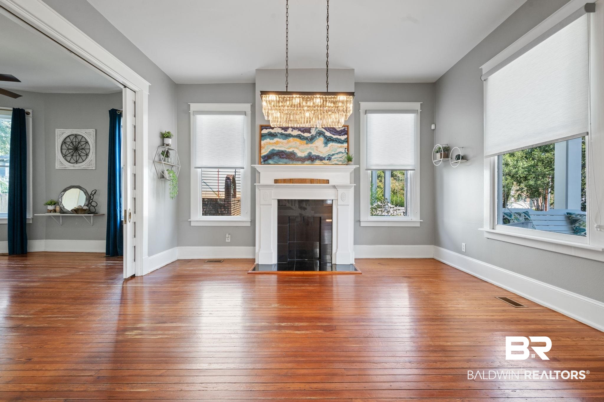 10 South Monterey Street Mobile, AL 36604 - Photo 9 of 45 Unfurnished living room featuring wood-type flooring, healthy amount of natural light, and a glass covered fireplace