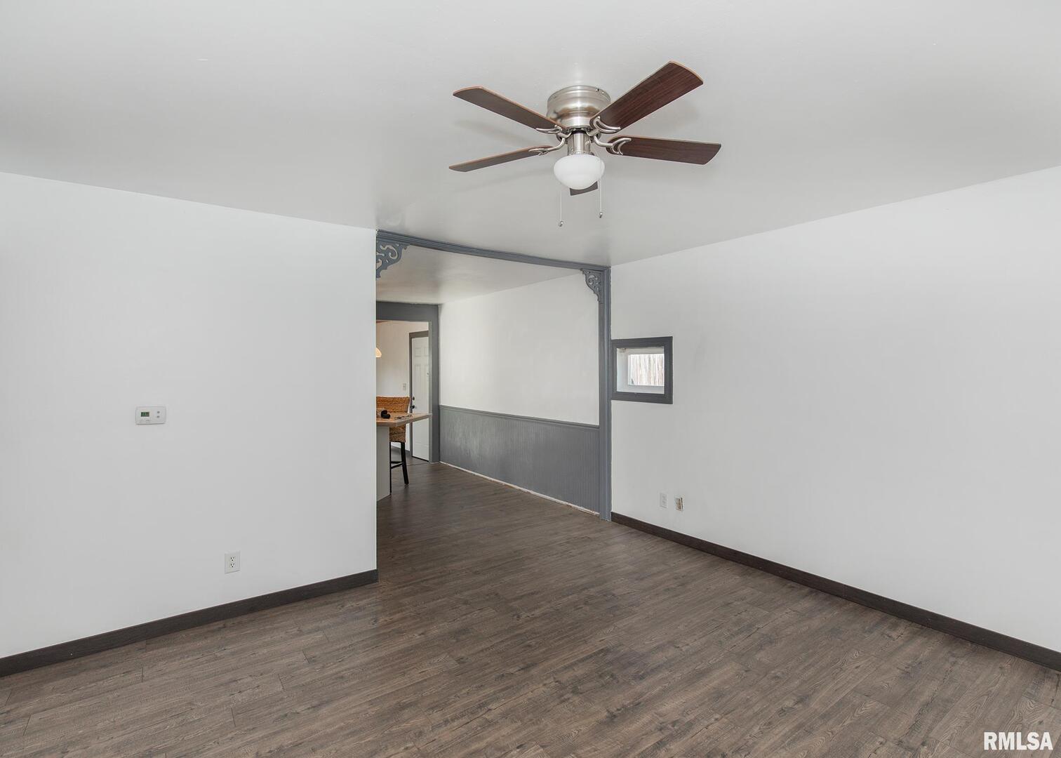 444 6th Street East Milan, IL 61264 - Photo 5 of 26 an empty room with wooden floor and a ceiling fan
