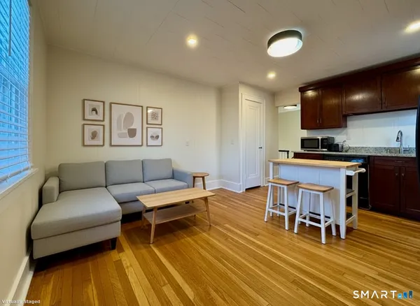 a living room with furniture and kitchen view