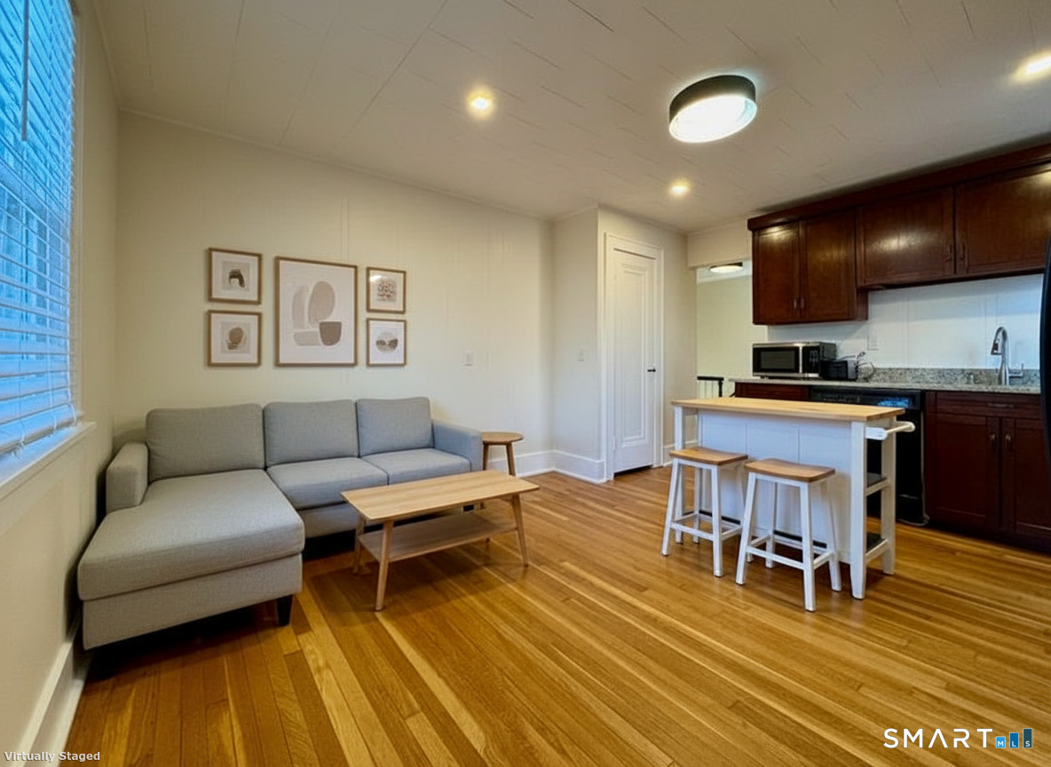a living room with furniture and kitchen view