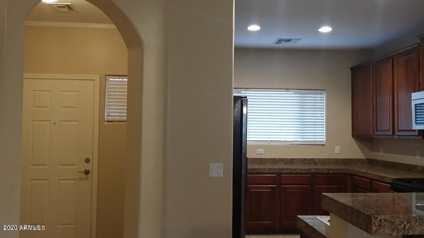 45434 West Rhea Road Maricopa, AZ 85139 - Photo 3 of 31 a kitchen with a refrigerator and cabinets