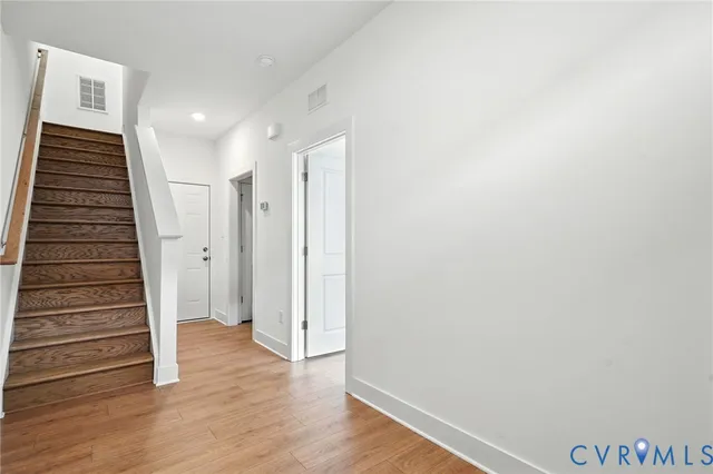 a view of a hallway with wooden floor and entryway