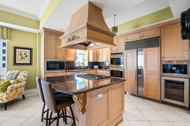 a kitchen with stainless steel appliances granite countertop a sink and a refrigerator