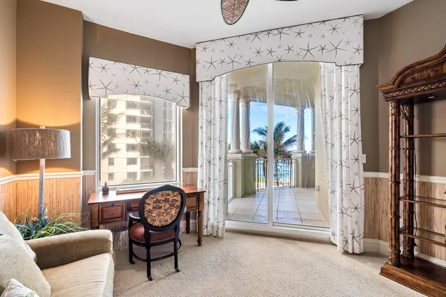 a living room with furniture a floor to ceiling window and a flat screen tv