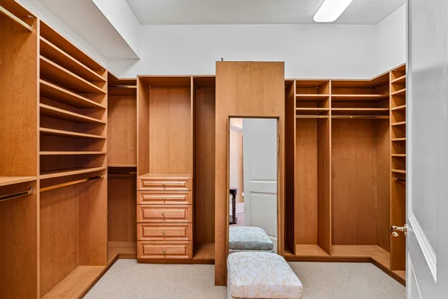 a view of walk in closet with clothes and shoes