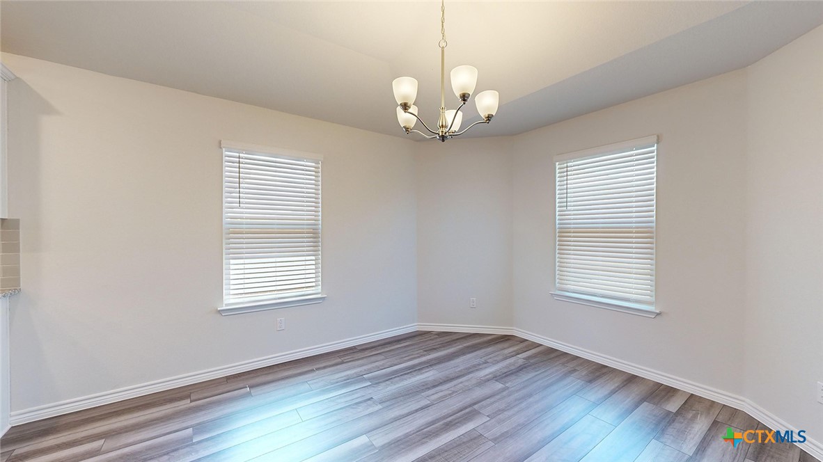 2057 Buckner Street Nolanville, TX 76559 - Photo 13 of 33 a view of an empty room with wooden floor and a window