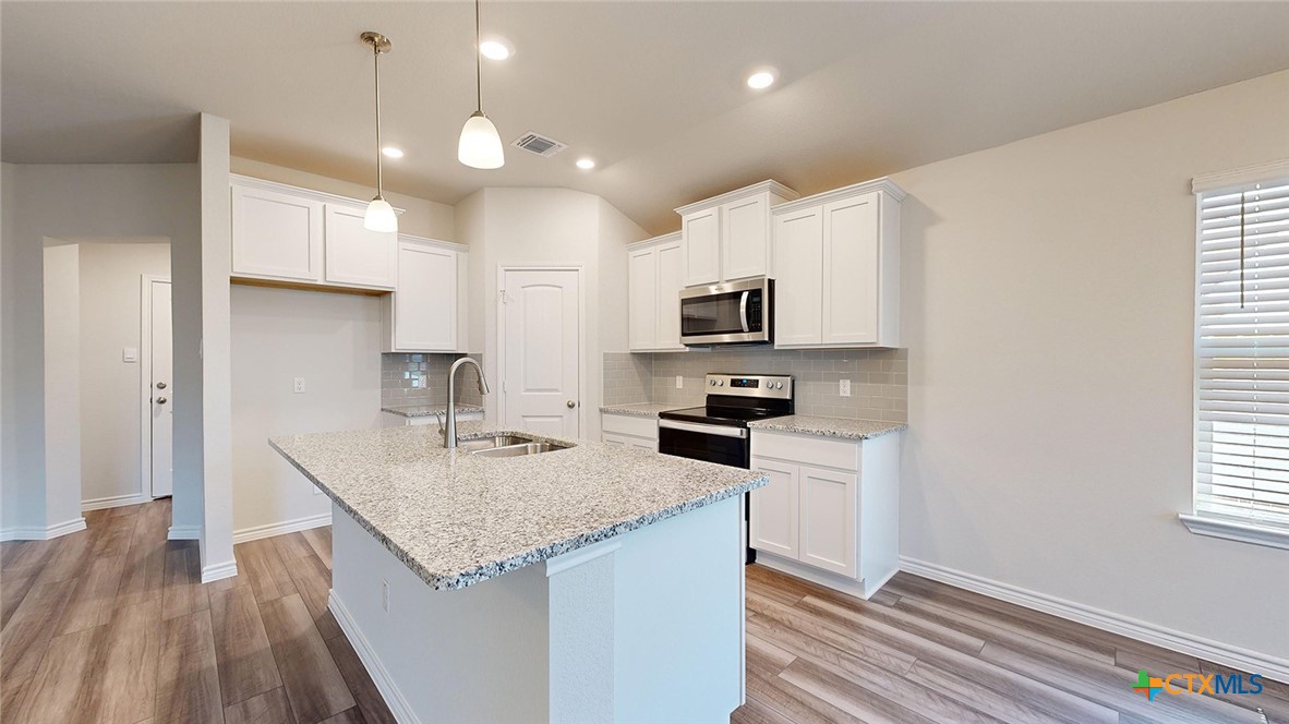 2057 Buckner Street Nolanville, TX 76559 - Photo 4 of 33 a kitchen with granite countertop a sink stove and refrigerator
