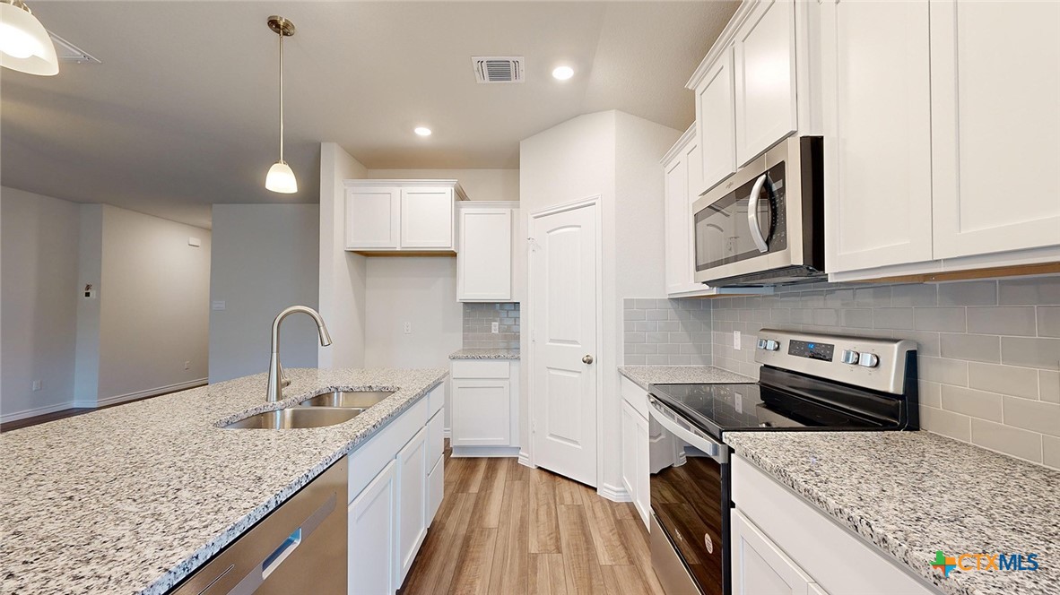 2057 Buckner Street Nolanville, TX 76559 - Photo 6 of 33 a kitchen with stainless steel appliances granite countertop a sink stove and cabinets
