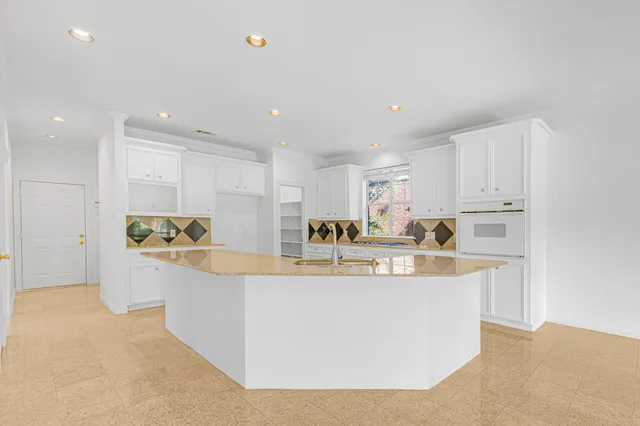 a kitchen with granite countertop a sink and white cabinets