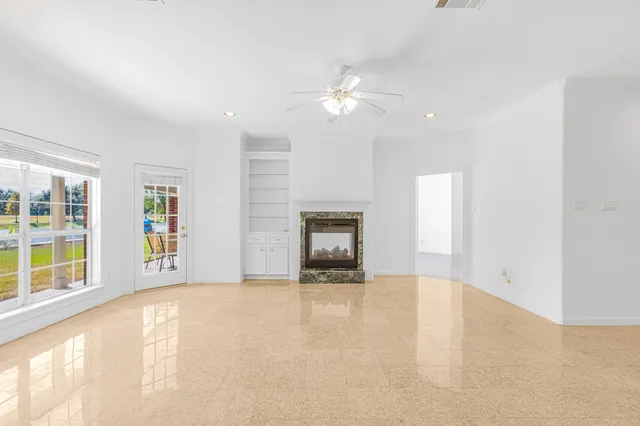 a view of an empty room with a fireplace and a window